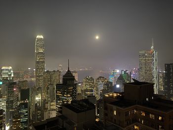 Illuminated buildings in city against sky at night