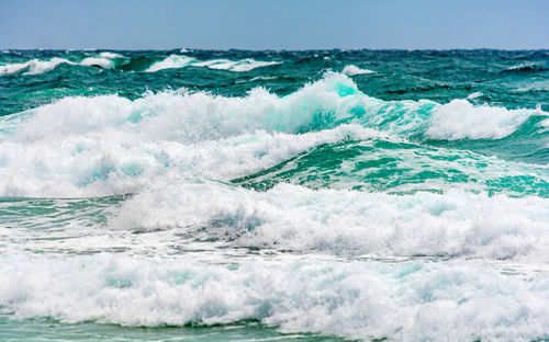 Turquoise colour ocean wave in windy day.