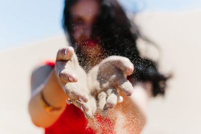 Woman throwing sand at desert