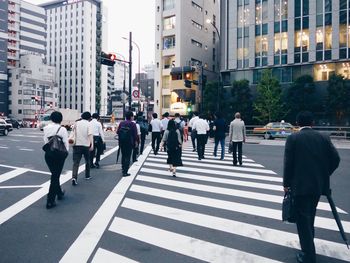 Group of people crossing road in city