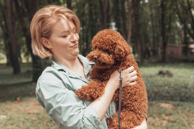 Side view of woman with dog on tree