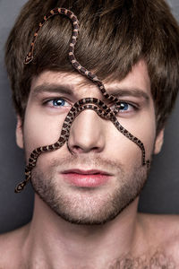 Snakes on face of young man