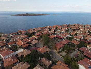 High angle view of townscape by sea against sky