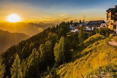 Scenic view of trees and buildings against sky during sunset