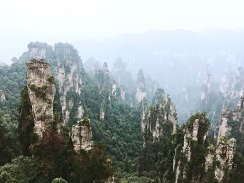 Scenic view of rocky mountains in foggy weather