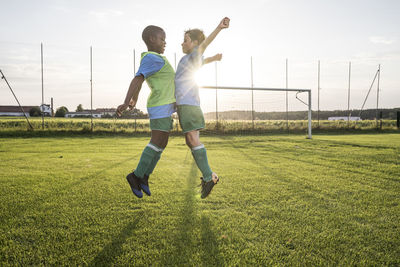 Young football players jumping on football ground