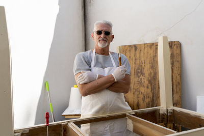 Professional carpenter is building a wooden table in his outdoor workshop