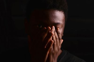 Close-up of man with obscured face in darkroom