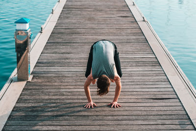 High angle view of man exercising on pier