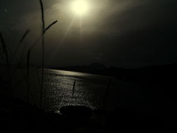 Close-up of illuminated sea against sky during sunset