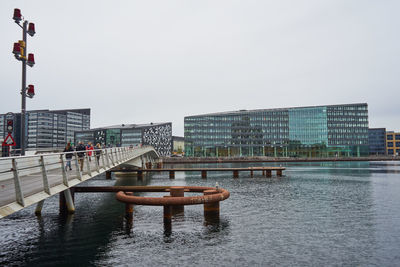 Scenic view of river by buildings against clear sky