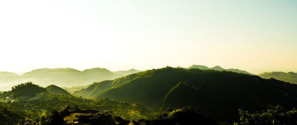 Panoramic view of green mountains against clear sky on sunny day