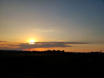 Scenic view of silhouette field against sky during sunset