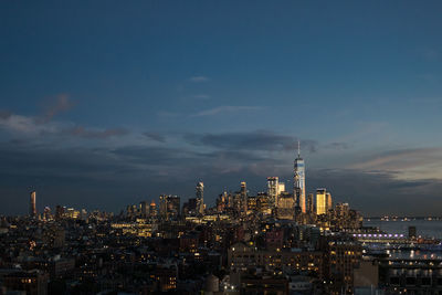 Illuminated buildings in city against sky