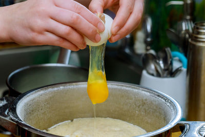 Cropped hand of man preparing food in kitchen