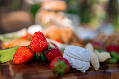 Picnic basket on a wooden table with strawberries.