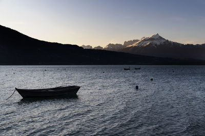 Boat in lake against sky during winter