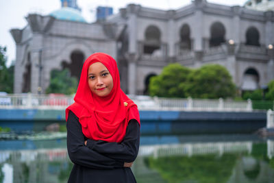 Portrait of woman standing against water