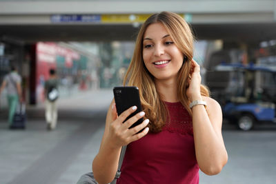 Smiling young woman using mobile phone