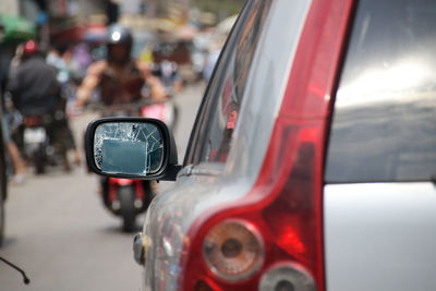 Close-up of car with broken side mirror on the road