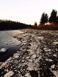 Scenic view of river against sky at sunset