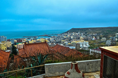 High angle view of townscape by sea against sky