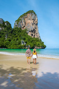 Rear view of couple walking on beach