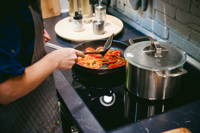 Midsection of woman preparing food in kitchen