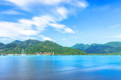 Scenic view of lake and mountains against blue sky