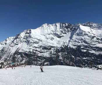 Scenic view of snowcapped mountains against clear blue sky