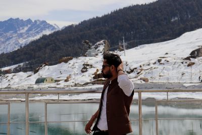 Man walking by lake against mountains