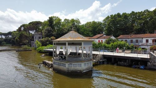 Built structure by river against sky