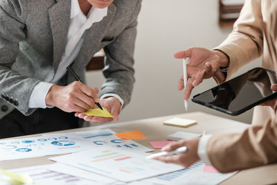 Midsection of business people working at office