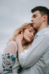 Couple standing against sky