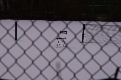 View of basketball hoop seen through chainlink fence