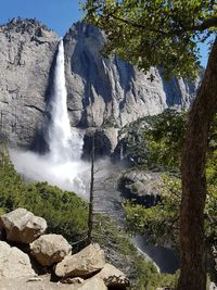 Scenic view of waterfall against sky