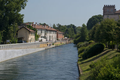 Scenic view of river by buildings against sky