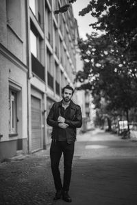 Full length portrait of young man standing in city