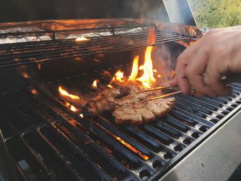 Close-up of man cooking on barbecue grill