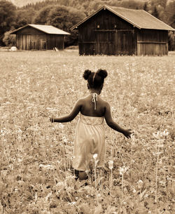 Rear view of woman standing on field