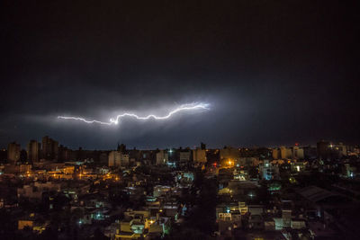 High angle view of illuminated city against sky at night