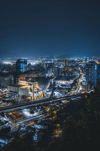 Illuminated cityscape against sky at night