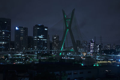 Illuminated buildings in city against sky at night