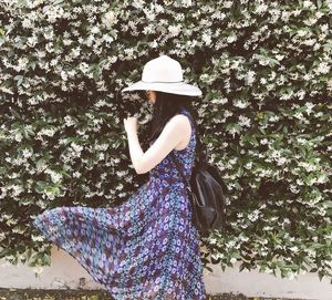 Rear view of woman standing against tree