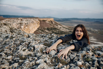 Young woman sitting on rock