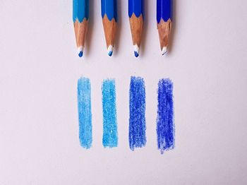 High angle view of colored pencils on white background