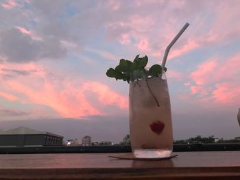 Close-up of drink on table against sky during sunset