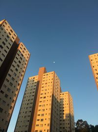 Low angle view of buildings against clear blue sky