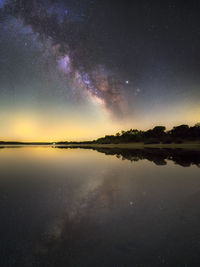 Scenic view of lake against sky at night