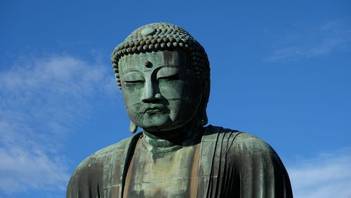 Low angle view of statue against blue sky